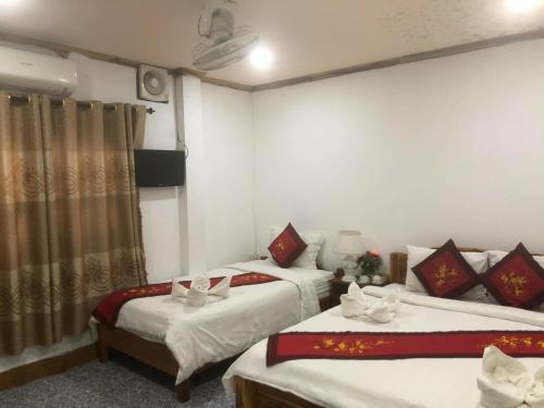 um quarto de hotel com duas camas e uma cortina em Nocknoy Lanexang Guest House em Luang Prabang