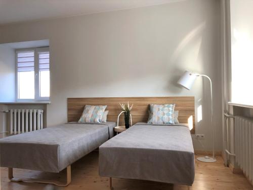 - une chambre avec deux lits et une lampe dans l'établissement COMFY Patogūs namai, à Kaunas