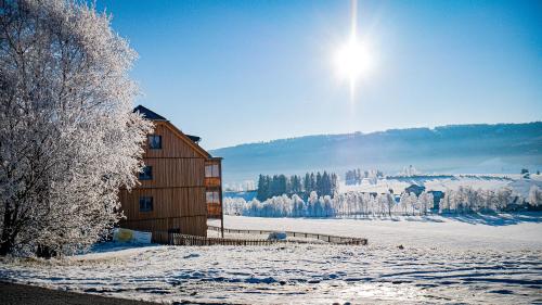 a building in the snow with the sun in the sky w obiekcie Haus Weigt w mieście Mariapfarr