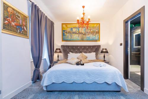 una camera da letto con un grande letto e un lampadario a braccio di Dubrovnik Old Town Apartments a Dubrovnik