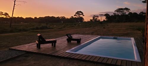 two chairs sitting on a deck next to a swimming pool at Solar de la Viuda in Punta Del Diablo