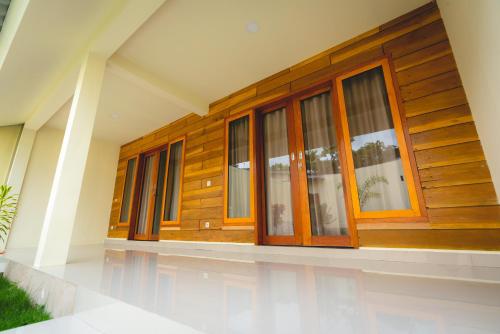 a house with wooden doors and windows at GREEN RINJANI in Bayan