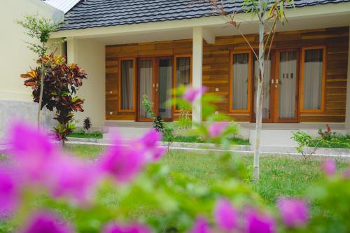 a house with pink flowers in front of it at GREEN RINJANI in Bayan