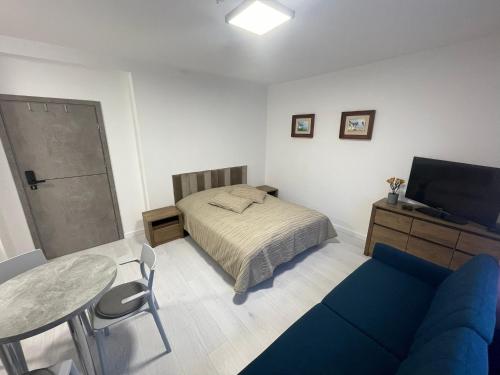 een slaapkamer met een bed en een tafel en een blauwe bank bij Apartamenty Wisła Centrum in Wisła