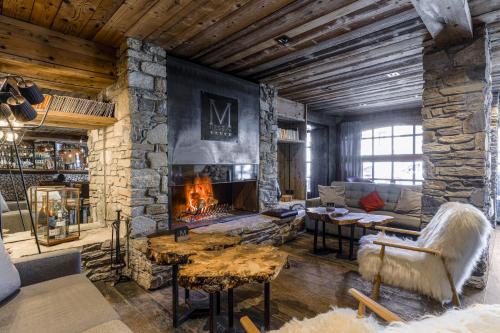 een woonkamer met een grote stenen open haard bij M de Megève in Megève