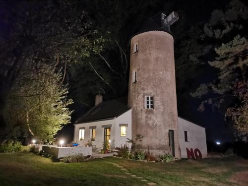 オルヴォーにあるLe moulin de La Retardièreの夜時計塔のある白い家