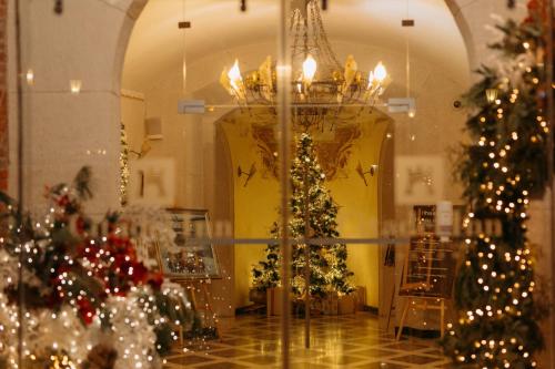 uma sala cheia de árvores de Natal e um lustre em Citadel Gastro Boutique Hotel em Lviv