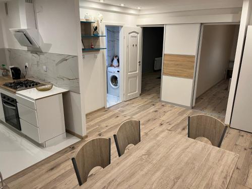 kuchnia i salon ze stołem i krzesłami w obiekcie Apartament Centrum Okulickiego ! w mieście Stalowa Wola