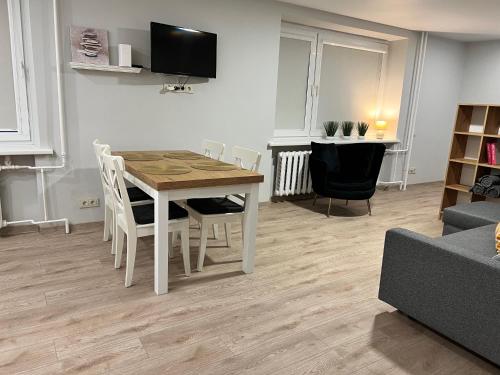 - un salon avec une table et des chaises en bois dans l'établissement Saulėti apartamentai Trakuose/Sunny apartment in Trakai, à Trakai