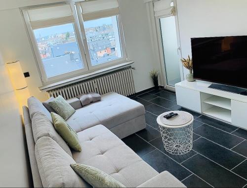 salon z kanapą i telewizorem z płaskim ekranem w obiekcie Esch/Alzette city apartment w mieście Esch-sur-Alzette