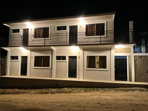 - une maison blanche avec balcon la nuit dans l'établissement Wally’s Place, à Estelí