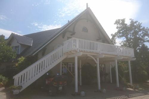 Una gran casa blanca con una escalera blanca en Schleiblick im Andersenhof, en Kappeln