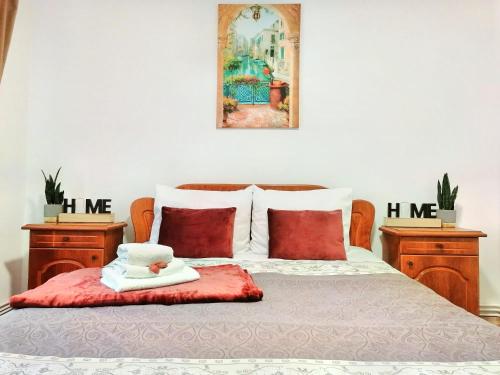 a bedroom with a bed with two tables and a picture on the wall at Apartament Cetate in Alba Iulia