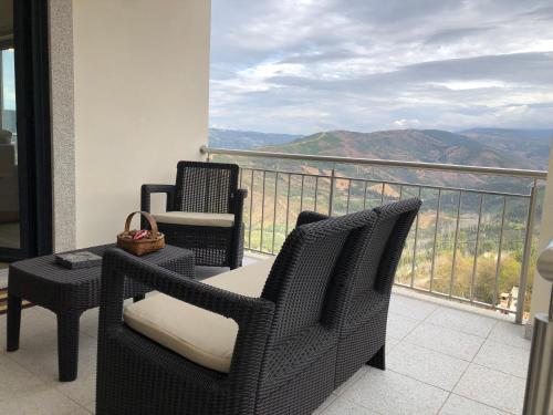 Un balcón con sillas y una mesa con vistas. en Casa da Forja, en Aldeia das Dez