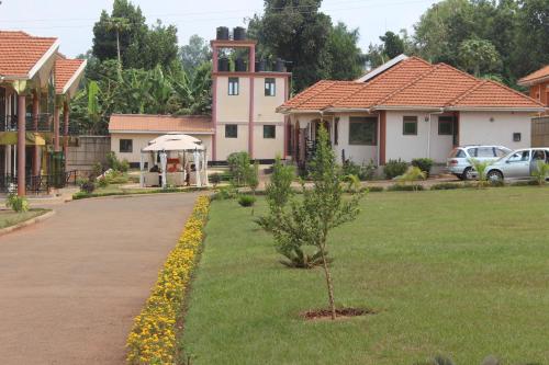 une maison avec un arbre au milieu d'une cour dans l'établissement Signature Hotel Apartments, à Jinja