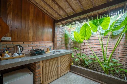 a kitchen with a sink and a large window at The Tetamian Bali in Sukawati