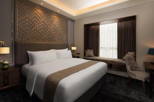 a hotel room with a large bed and a window at Sutasoma Hotel in Jakarta