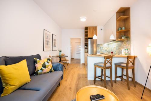 een woonkamer met een blauwe bank en een keuken bij Mokotów Passion Apartment in Warschau