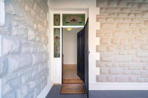 un couloir avec un mur en briques et une porte dans l'établissement Emilias' Place - Mile End City Fringe, à Keswick