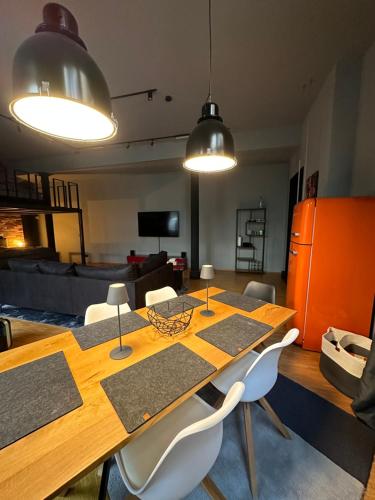 uma sala de jantar com uma mesa de madeira e cadeiras brancas em Loft mit privater Sauna em Heidelberg