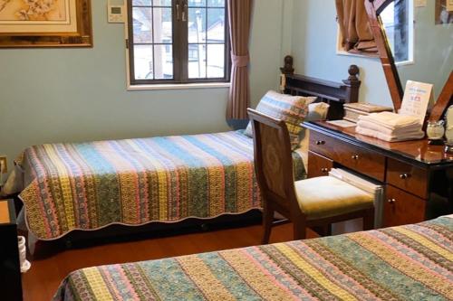 a room with two beds and a desk and a chair at Nikko Park Lodge Mountain Side in Nikko