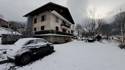 samochód zaparkowany przed domem pokrytym śniegiem w obiekcie Tres bel appartement dans une maison avec SPA w mieście Séez