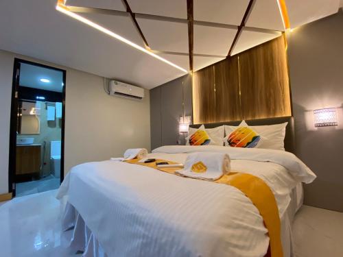 a bedroom with two beds and a window at NGN Gran Hotel in Tuguegarao City