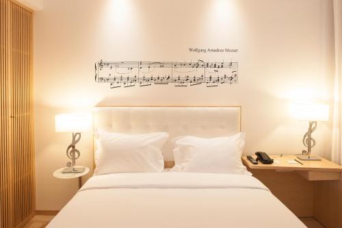 - une chambre dotée d'un lit avec des notes musicales sur le mur dans l'établissement Hotel da Música, à Porto