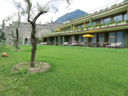 un edificio con un albero in mezzo a un cortile di Hotel Alexander a Limone sul Garda