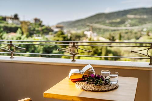 una mesa con libros y gafas en el balcón en Sivota Diamond Spa Resort, en Sivota