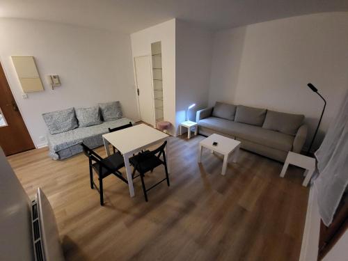 a living room with a couch and a table at Charmant studio Porte St Cloud in Boulogne-Billancourt