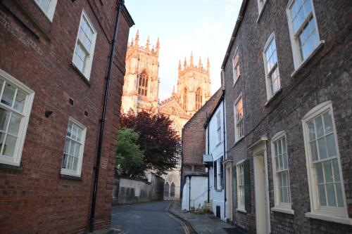 un vicolo con cattedrale sullo sfondo con edifici in mattoni di 7 Precentor's Court a York