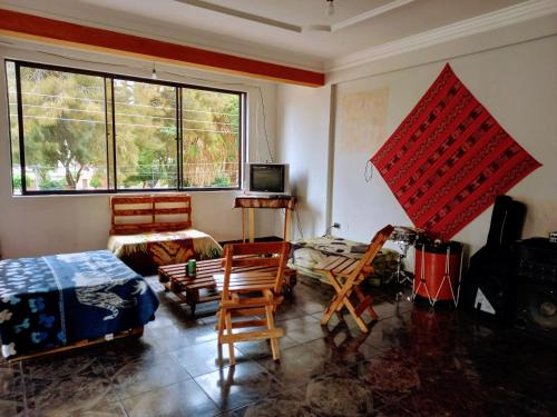 ein Wohnzimmer mit Stühlen, einem Tisch und Fenstern in der Unterkunft La Casita Feliz...!!! in Cochabamba