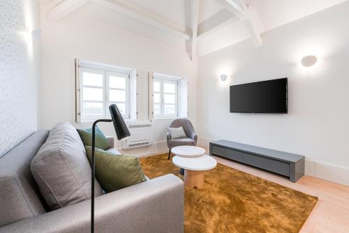 a living room with a couch and a tv at Door 65 - Historical Center Apartments in Porto