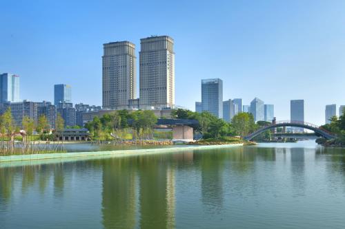 une rivière avec un pont et une ville en arrière-plan dans l'établissement Oakwood Residence Foshan, à Foshan