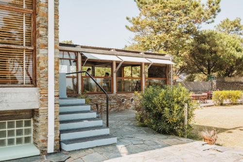 a house with a staircase leading up to a building at Parque do Rio Ofir Hotel in Esposende