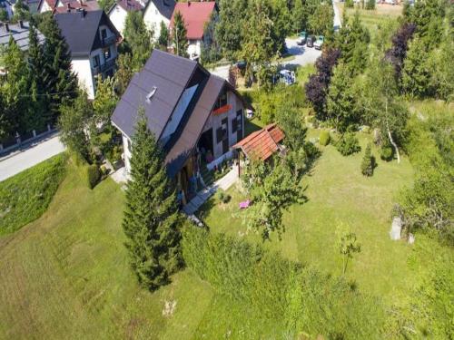 une vue sur une maison sur un champ verdoyant dans l'établissement Apartment Monte Rosa, à Delnice