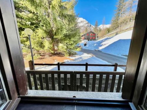 een uitzicht vanuit een raam op een met sneeuw bedekte tuin bij Chalet le Pigne Gressoney Saint Jean in Gressoney-Saint-Jean