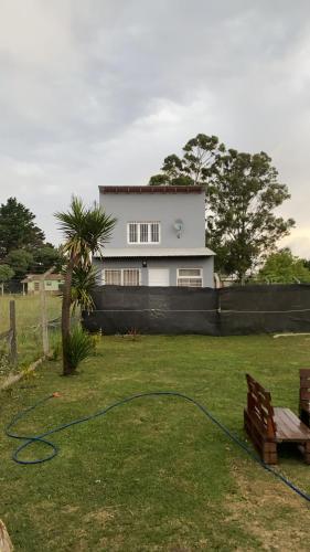 een huis met een tuin met een groene slang bij Casita Santa Ana Miramar Buenos Aires in Miramar