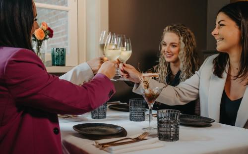 Due donne che tengono bicchieri da vino a tavola di Kasteel de Wittenburg a Wassenaar