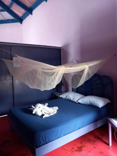 um quarto com uma cama com uma rede mosquiteira em Il Triangolo Hostel em Las Galeras