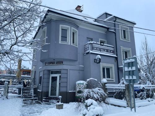 un bâtiment bleu avec un panneau dans la neige dans l'établissement U Lupka - Ostrava, à Ostrava