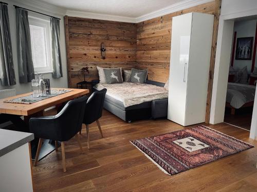 um quarto com uma cama, uma mesa e um frigorífico em Apartment close to the ski area em Wald im Pinzgau