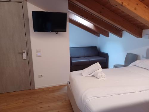 a bedroom with a bed and a couch and a television at Superior Beach Aparthotel in Lido di Jesolo