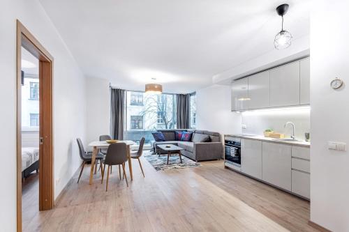 a kitchen and living room with a table and chairs at Business Apartment In Jaksto Street in Vilnius