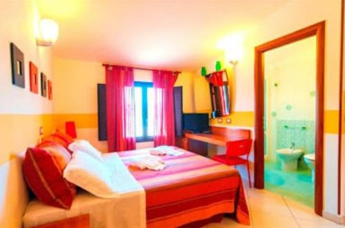 - une chambre colorée avec un lit et une salle de bains dans l'établissement Villa Sunset B&B/Apartments, à Fontane Bianche