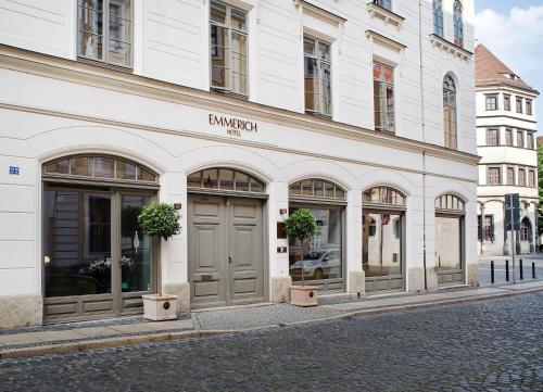 un edificio bianco con un negozio con finestre frontali di Emmerich Hotel Görlitz a Görlitz