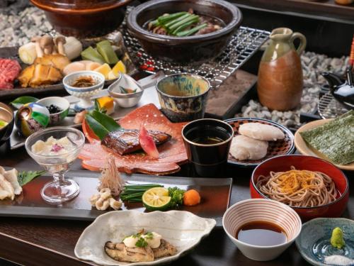 een tafel met veel verschillende soorten voedsel erop bij Bettei Fujiya in Miyajima