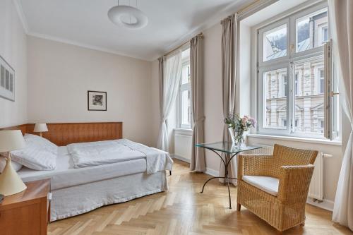 um quarto com uma cama, uma mesa e uma cadeira em Hotel Palatin em Karlovy Vary