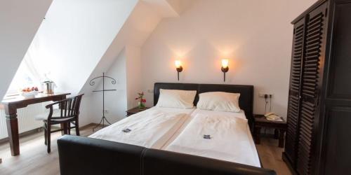 a bedroom with a bed and a desk and a chair at Hotel zur Römerbrücke in Neuwied